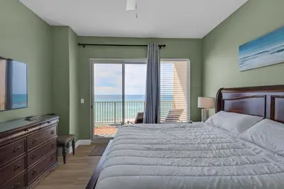 a bedroom with a bed and a view of the ocean at Treasure Island 0307 in Panama City Beach