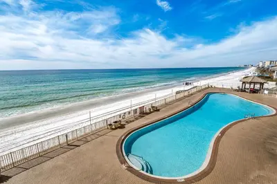 a swimming pool next to a beach and the ocean at Treasure Island 0307 in Panama City Beach