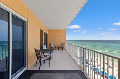 a balcony with a table and chairs and the ocean at Treasure Island 0403 in Panama City Beach