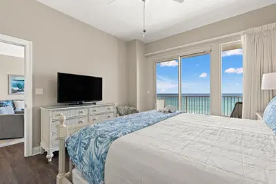 a bedroom with a bed and a tv and windows at Treasure Island 0403 in Panama City Beach