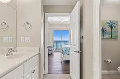 a bathroom with a sink and a door to the ocean at Treasure Island 0403 in Panama City Beach