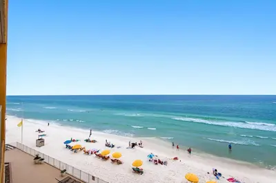 a group of people on a beach with umbrellas at Treasure Island 0403 in Panama City Beach