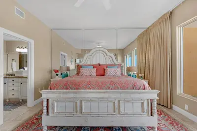 a bedroom with a large bed with red pillows at Treasure Island 0412 in Panama City Beach