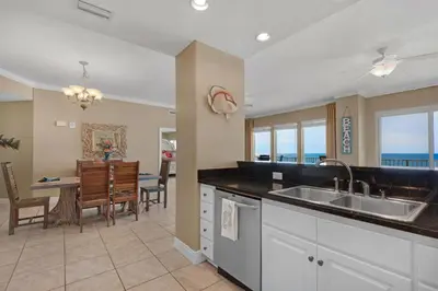 a kitchen and dining room with a view of the ocean at Treasure Island 0412 in Panama City Beach