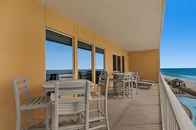 a balcony with tables and chairs and the ocean at Treasure Island 0412 in Panama City Beach