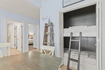 a bedroom with a bunk bed and a table at Treasure Island 0411 in Panama City Beach