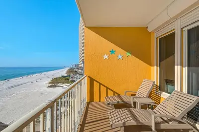 a balcony with two chairs and the beach at Treasure Island 0411 in Panama City Beach