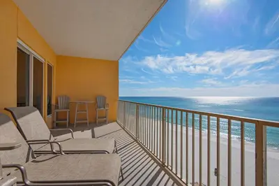 a balcony with chairs and a view of the ocean at Treasure Island 0506 in Panama City Beach