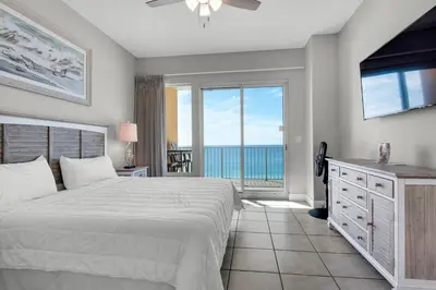 a bedroom with a bed and a view of the ocean at Treasure Island 0506 in Panama City Beach