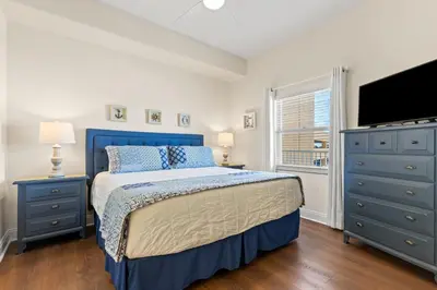 a bedroom with a bed and a flat screen tv at Treasure Island 0503 in Panama City Beach
