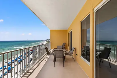 a balcony with a table and chairs and the ocean at Treasure Island 0503 in Panama City Beach