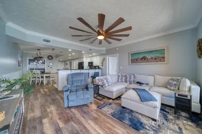 a living room with a couch and a ceiling fan at Treasure Island 0906 in Panama City Beach