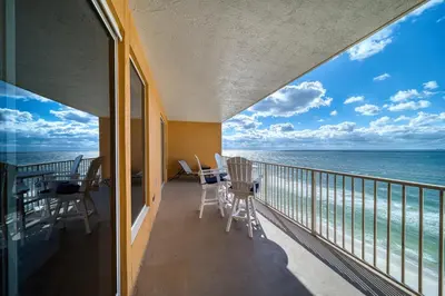 a balcony with chairs and a view of the ocean at Treasure Island 0906 in Panama City Beach