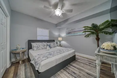 a bedroom with a bed and a ceiling fan at Treasure Island 0906 in Panama City Beach