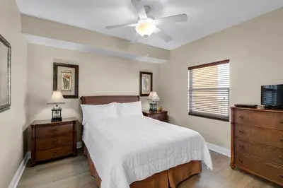 a bedroom with a bed and a ceiling fan at Treasure Island 1003 in Panama City Beach
