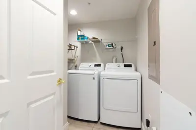 a white laundry room with two washes and a washer at Treasure Island 1109 in Panama City Beach