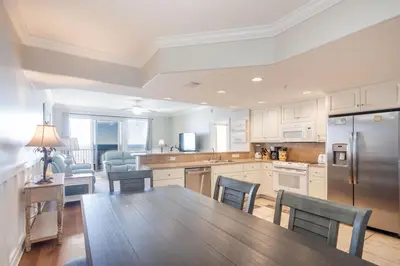 a kitchen with a table and chairs and a refrigerator at Treasure Island 1109 in Panama City Beach