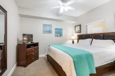 a bedroom with a bed and a flat screen tv at Treasure Island 1109 in Panama City Beach