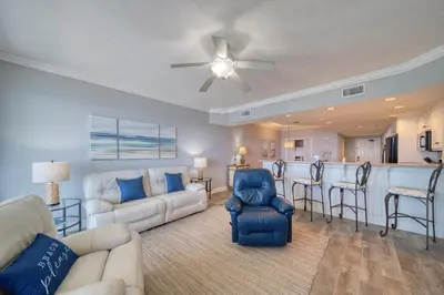 a living room with a couch and a bar at Treasure Island 1610 in Panama City Beach