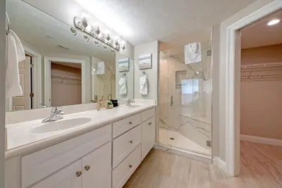 a white bathroom with a sink and a shower at Treasure Island 2006 in Panama City Beach
