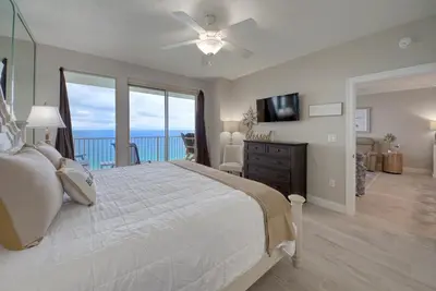 a bedroom with a bed and a view of the ocean at Treasure Island 2006 in Panama City Beach