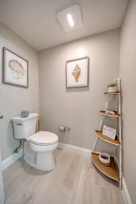 a bathroom with a white toilet and a shelf at Treasure Island 2006 in Panama City Beach