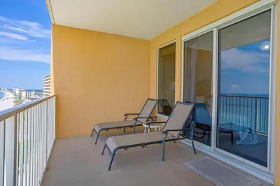 a balcony with chairs and tables on a building at Treasure Island 1905 in Panama City Beach