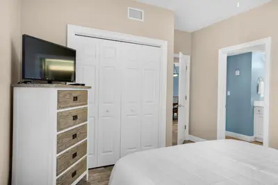 a bedroom with a bed and a tv on a dresser at Treasure Island 1905 in Panama City Beach