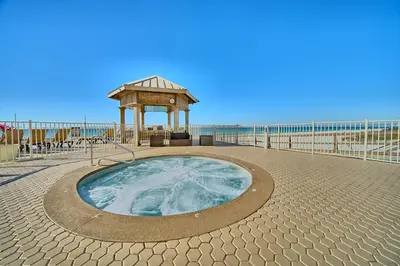 a hot tub with a gazebo next to the beach at Treasure Island 1905 in Panama City Beach