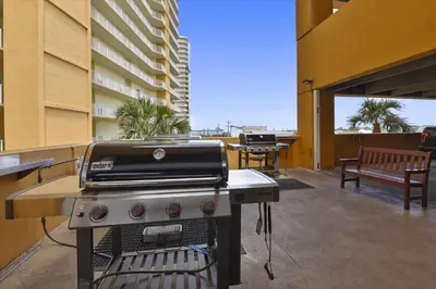 a grill on an outdoor patio with a building at Treasure Island 1905 in Panama City Beach