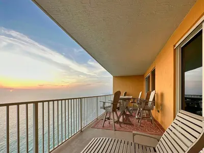 a balcony with a table and chairs and the ocean at Treasure Island 2202 in Panama City Beach