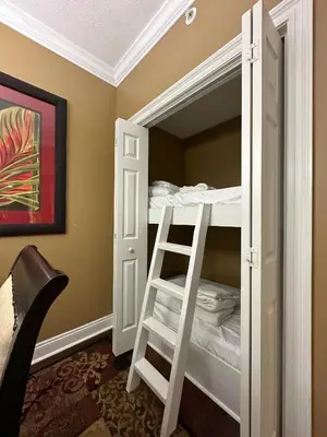 a white bunk bed in a room with a ladder at Treasure Island 2202 in Panama City Beach