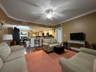 a living room with two couches and a flat screen tv at Treasure Island 2202 in Panama City Beach