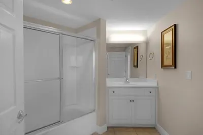 a white bathroom with a shower and a sink at Treasure Island 2312 in Panama City Beach