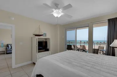 a bedroom with a bed and a view of the ocean at Treasure Island 0111 in Panama City Beach
