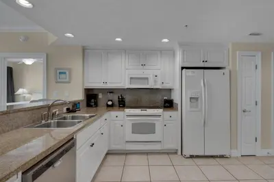 a kitchen with white cabinets and a white refrigerator at Treasure Island 0111 in Panama City Beach