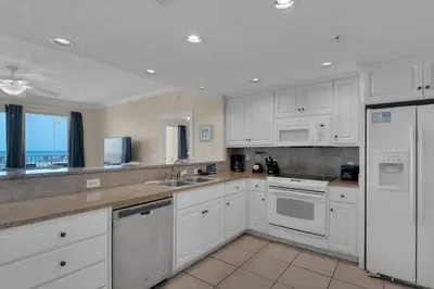 a white kitchen with white cabinets and appliances at Treasure Island 0111 in Panama City Beach