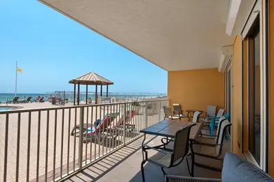 a balcony with a table and chairs and the beach at Treasure Island 0111 in Panama City Beach