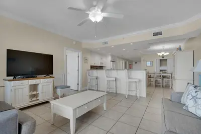 a living room with a couch and a flat screen tv at Treasure Island 0111 in Panama City Beach