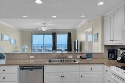 a kitchen with a sink and a view of the ocean at Treasure Island 0111 in Panama City Beach