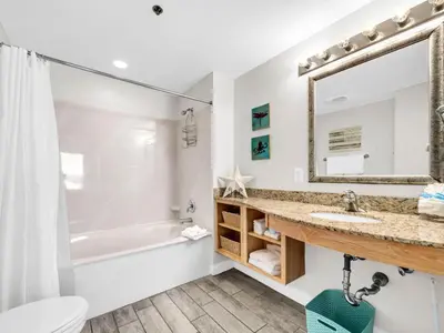 a bathroom with a sink and a tub and a toilet at Splash 1505E in Panama City Beach