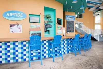 a bar with blue chairs in a restaurant at Splash 1505E in Panama City Beach