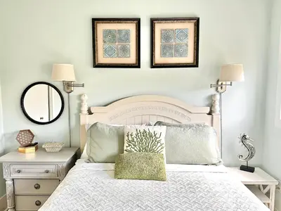 a bedroom with a white bed and two pictures on the wall at Saltwater Gospel in Inlet Beach