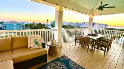 a porch with a couch and a table on a balcony at Saltwater Gospel in Inlet Beach