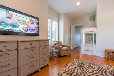 a living room with a flat screen tv on a dresser at Pelican Paradise - Unit A in Seacrest