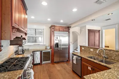 a kitchen with wooden cabinets and a stainless steel refrigerator at Pelican Paradise Unit B in Seacrest