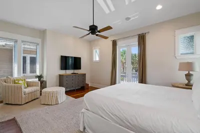 a bedroom with a white bed and a tv at Pelican Paradise Unit B in Seacrest