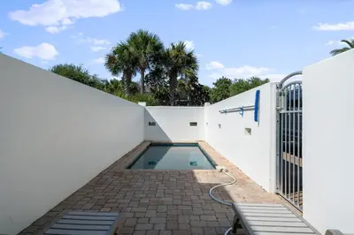 a swimming pool in the side of a white building at Pelican Paradise Unit B in Seacrest