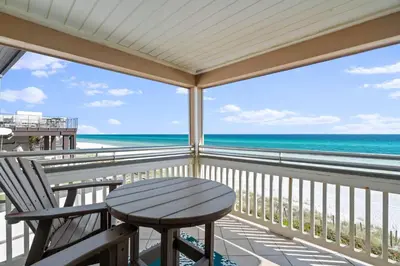 a balcony with a table and a view of the ocean at Pelican Paradise Unit B in Seacrest