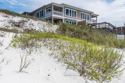 a house sitting on top of a sandy beach at Pelican Paradise in Seacrest